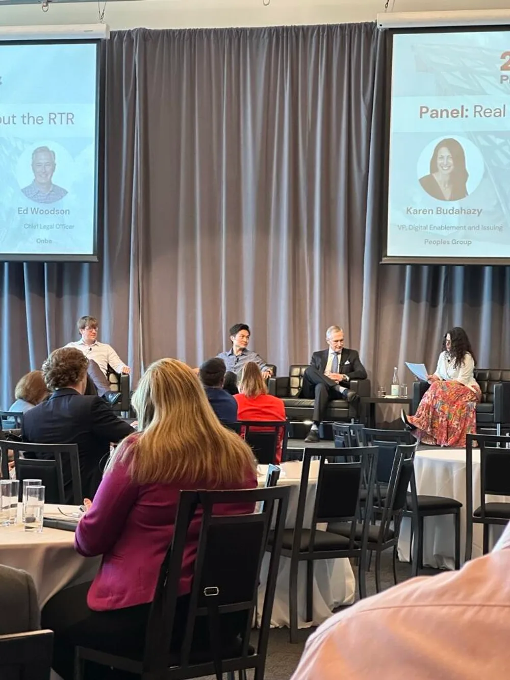 A panel discussion at a payments industry conference, with speakers on stage in front of an audience